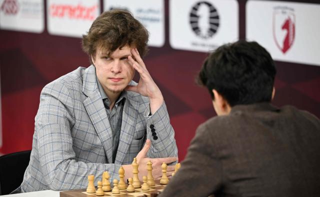 Russia's Russian Vladislav Artemiev (L) plays during the 11th round of the FIDE World Rapid and Blitz Championships 2025 at the Sports and Events Complex, at Qatar University in Doha on December 28, 2025. (Photo by MAHMUD HAMS / AFP)