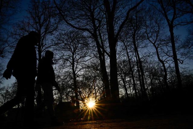 People go for a walk on a sunny afternoon at a public city garden in Berlin’s Steglitz district on December 28, 2025. (Photo by Tobias SCHWARZ / AFP)