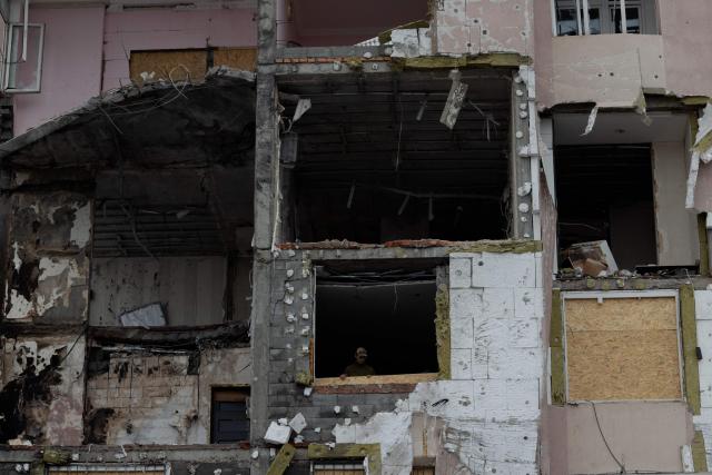 A man stands inside a damaged residential building following Russian drones and missiles attack, in Kyiv, on December 28, 2025, amid the Russian invasion in Ukraine. A Russian drone and missile barrage on Kyiv and its suburbs killed one person, wounded two dozen and cut off heating and electricity for hundreds of thousands of people left in freezing temperatures on December 27, 2025. (Photo by Tetiana DZHAFAROVA / AFP)
