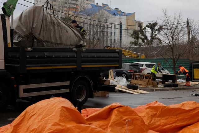 Workers prepare plywood for damaged windows in a damaged residential building following Russian drones and missiles attack, in Kyiv, on December 28, 2025, amid the Russian invasion in Ukraine. A Russian drone and missile barrage on Kyiv and its suburbs killed one person, wounded two dozen and cut off heating and electricity for hundreds of thousands of people left in freezing temperatures on December 27, 2025. (Photo by Tetiana DZHAFAROVA / AFP)