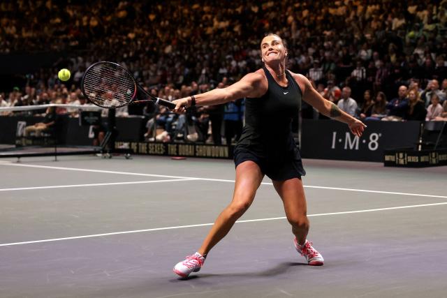 Belarus’ Aryna Sabalenka hits a return against Australia's Nick Kyrgios during the Battle of the Sexes exhibition tennis match in Dubai on December 28, 2025. (Photo by Christopher Pike / POOL / AFP)