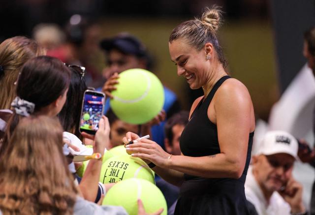 Belarus’ Aryna Sabalenka signs autographs for fans after  her Battle of the Sexes exhibition tennis match against Australia's Nick Kyrgios in Dubai on December 28, 2025. (Photo by Amr Alfiky / POOL / AFP)