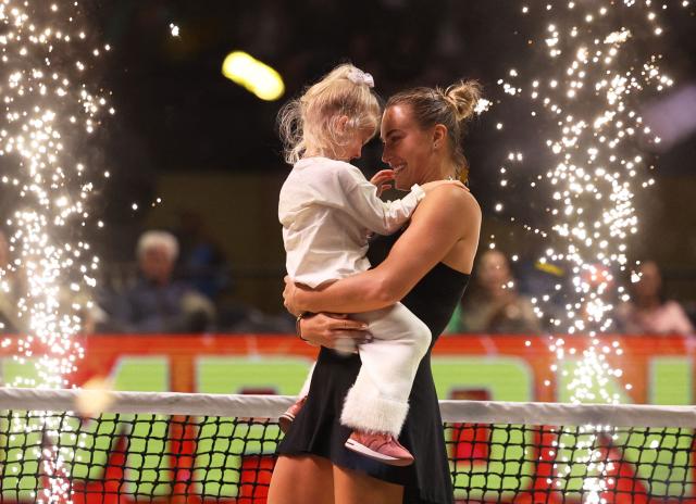 Belarus' Aryna Sabalenka celebrates with her goddaughter Nicole after her Battle of the Sexes exhibition tennis match against Australia's Nick Kyrgios in Dubai on December 28, 2025. Kyrgios won the match. (Photo by Amr Alfiky / POOL / AFP)