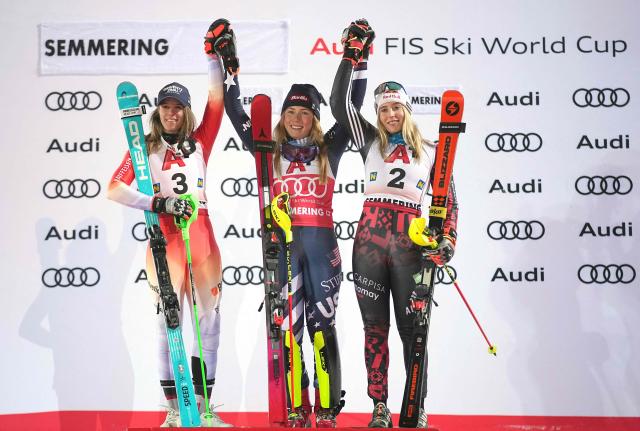 (L-R) Second placed Switzerland's Camille Rast, winner USA's Mikaela Shiffrin and third placed Albania's Lara Colturi celebrate on the podium after the Women's Slalom race of the FIS Alpine Ski World Cup in Semmering, Austria on December 28, 2025. (Photo by GEORG HOCHMUTH / APA / AFP) / Austria OUT