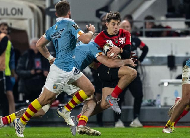 Toulon's French full-back Mathis Ferte (R) is tackled during the French Top14 rugby union match between Toulon and Perpignan at the Mayol stadium in Toulon, southeatern France, on December 28, 2025. (Photo by MIGUEL MEDINA / AFP)