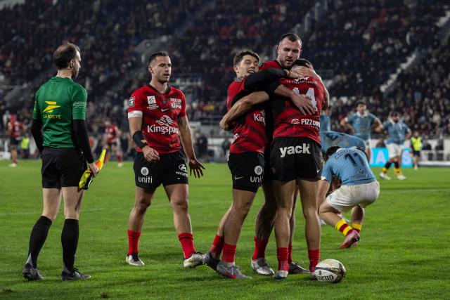 Toulon's French wing Gael Drean (R) is congratulated by team mates after scoring a try during the French Top14 rugby union match between Toulon and Perpignan at the Mayol stadium in Toulon, southeatern France, on December 28, 2025. (Photo by MIGUEL MEDINA / AFP)