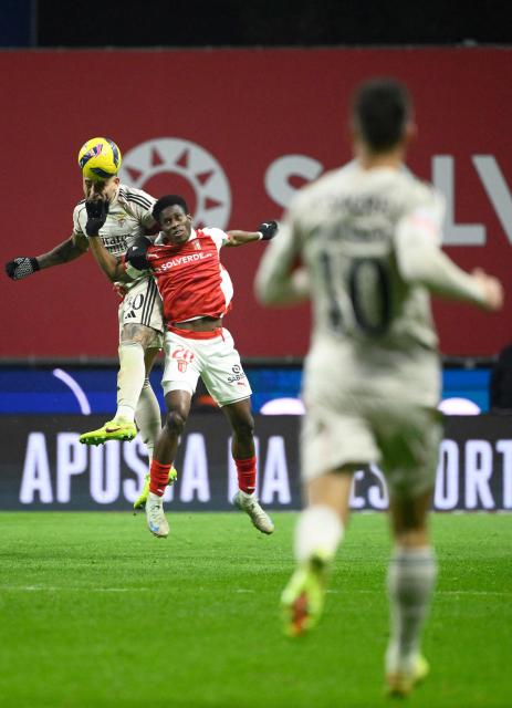 SL Benfica's Argentine defender #30 Nicolas Otamendi and Sporting Braga's Ivorian midfielder #20 Mario Dorgeles vie for a header during the Portuguese League football match between SC Braga and SL Benfica at Municipal Stadium in Braga on December 28, 2025. (Photo by Miguel RIOPA / AFP)