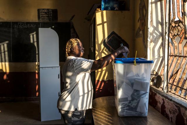 A voter casts her ballot at the Federico Mayor Primary School during Guinea's presidential election, in Conakry, on December 28, 2025. (Photo by PATRICK MEINHARDT / AFP)