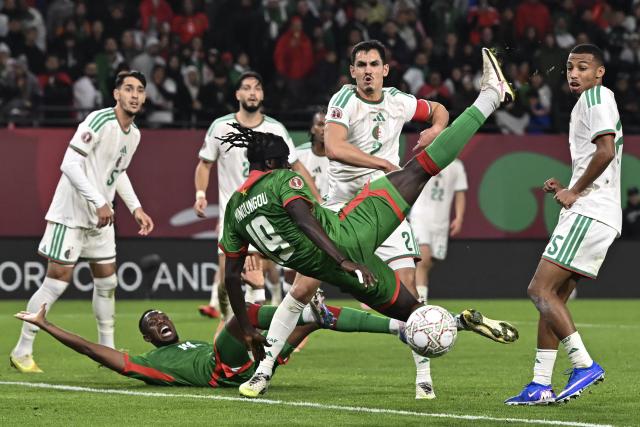 Burkina Faso's forward #19 Georgi Minoungou (C) tries to shoot the ball during the Africa Cup of Nations (CAN) Group E football match between Algeria and Burkino Faso at Moulay Hassan Stadium in Rabat on December 28, 2025. (Photo by Paul ELLIS / AFP)