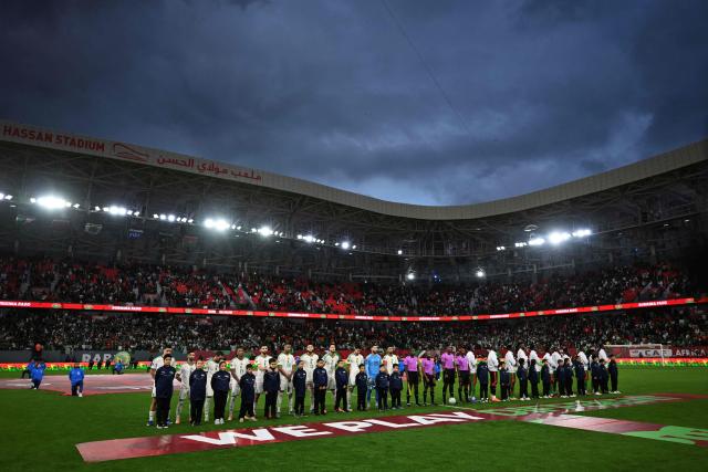 Players stad on the pitch before the Africa Cup of Nations (CAN) Group E football match between Algeria and Burkino Faso at Moulay Hassan Stadium in Rabat on December 28, 2025. (Photo by Paul ELLIS / AFP)