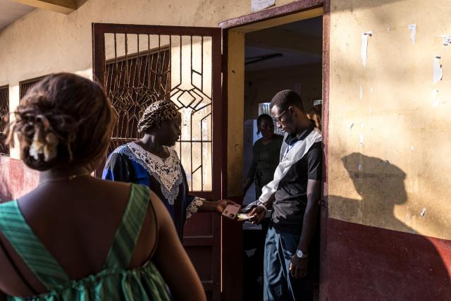 An official of the General Directorate of Elections (DGE) checks a voter’s information at the Federico Mayor Primary School during Guinea's presidential election, in Conakry, on December 28, 2025. (Photo by PATRICK MEINHARDT / AFP)