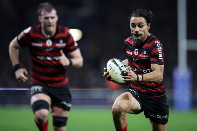 Toulouse's Italian wing Ange Capuozzo (R) runs to score a try during the French Top14 rugby union match between Stade Toulousain Rugby (Toulouse) and Stade Rochelais (La Rochelle) at the Ernest-Wallon stadium in Toulouse, south-western France on December 28, 2025. (Photo by Valentine CHAPUIS / AFP)
