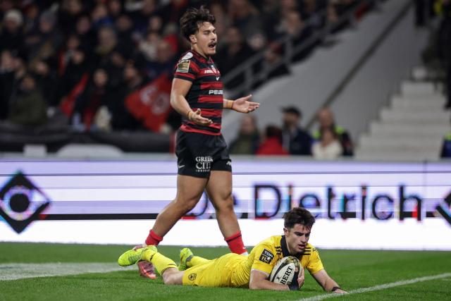 La Rochelle's French scrum-half Nolann Le Garrec (bottom) scores a try during the French Top14 rugby union match between Stade Toulousain Rugby (Toulouse) and Stade Rochelais (La Rochelle) at the Ernest-Wallon stadium in Toulouse, south-western France on December 28, 2025. (Photo by Valentine CHAPUIS / AFP)