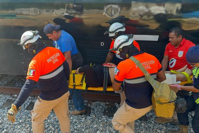 Civil Protection members rescue a woman from the Interoceanic train that derailed in the Asuncion Ixtaltepec area on the route to Oaxaca, Mexico on December 28, 2025. (Photo by Rusvel RASGADO / AFP)
