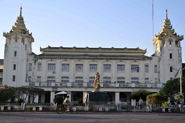 A trishaw driver rides past Yangon train station in Yangon on December 29, 2025. (Photo by Nhac NGUYEN / AFP)