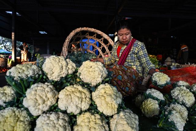 A vegetable vendor waits for customers at a market in Naypyidaw on December 29, 2025, a day after the first phase of Myanmar's general election. (Photo by Sai Aung MAIN / AFP)