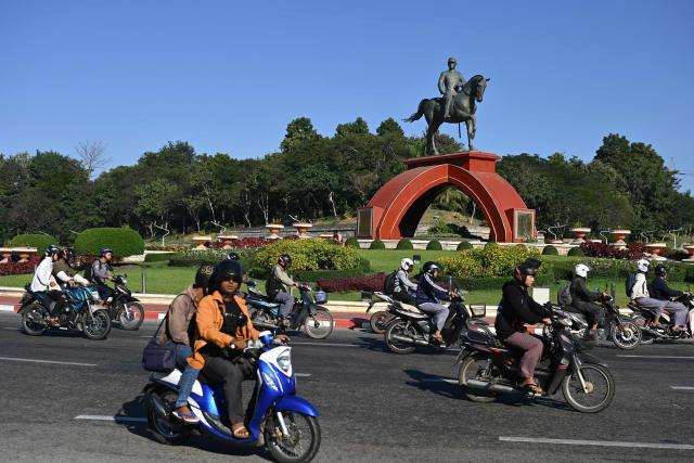Motorists drive past the statue of General Aung San in Naypyidaw on December 29, 2025, a day after the first phase of Myanmar's general election. (Photo by Sai Aung MAIN / AFP)