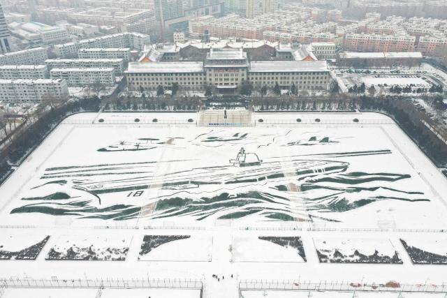 This aerial picture taken on December 28, shows a pattern of warship modelled after the Fujian aircraft carrier “painted” onto the snow by staff and students at Harbin Engineer University in Harbin, China’s northeast Heilongjiang province. (Photo by AFP) / China OUT