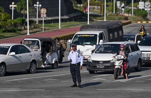 A traffic police personnel stands guard along a street in Naypyidaw on December 29, 2025, a day after the first phase of Myanmar's general election. (Photo by Sai Aung MAIN / AFP)