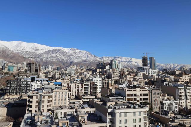A photograph shows the Iranian capital Tehran with the snow-covered Alborz mountain range in the background on December 29, 2025. Tehran has seen intermittent rain since early December after months of dry weather, partially replenishing some of the city's reservoirs but leaving overall levels critically low. Iran, a largely arid country, has for years suffered chronic dry spells and heat waves, which are expected to worsen with climate change. (Photo by ATTA KENARE / AFP)