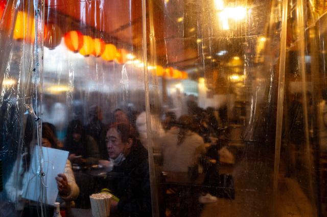 Customers eat at a restaurant in Tokyo's Ueno shopping district on December 29, 2025. (Photo by Philip FONG / AFP)