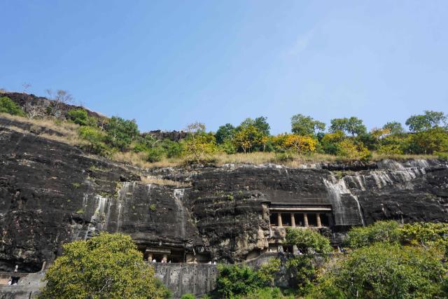 This photograph taken on December 14, 2025 shows tourists at the Ajanta Caves in Maharashtra. The Ajanta Caves are about 30 Buddhist cave monuments and temples that date from around the 2nd century BCE to around 480 CE, cut into the dark basalt rock of the Deccan Traps, the remnants of an immense volcanic event some 65 million years ago. The paintings and sculptures at the site are considered masterpieces of Buddhist religious art, according to UNESCO, which gave the caves World Heritage Site status in 1983. (Photo by Peter MARTELL / AFP)