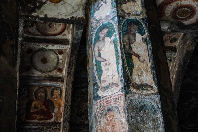 This photograph taken on December 14, 2025 shows a fresco painting featuring Buddha on the wall of a rock-cut hall at the Ajanta Caves in Maharashtra. The Ajanta Caves are about 30 Buddhist cave monuments and temples that date from around the 2nd century BCE to around 480 CE, cut into the dark basalt rock of the Deccan Traps, the remnants of an immense volcanic event some 65 million years ago. The paintings and sculptures at the site are considered masterpieces of Buddhist religious art, according to UNESCO, which gave the caves World Heritage Site status in 1983. (Photo by Peter MARTELL / AFP)