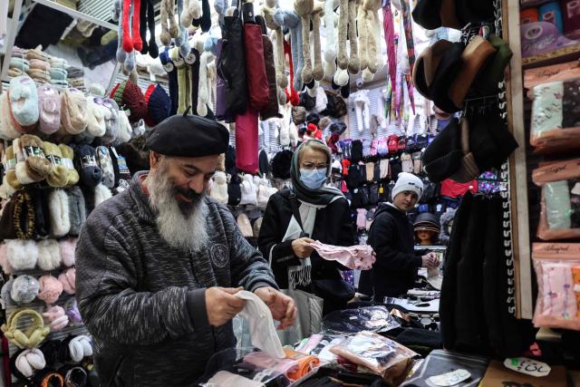 A shopkeeper tidies his stall in Tajrish Bazaar in the Iranian capital Tehran on December 29, 2025. (Photo by ATTA KENARE / AFP)
