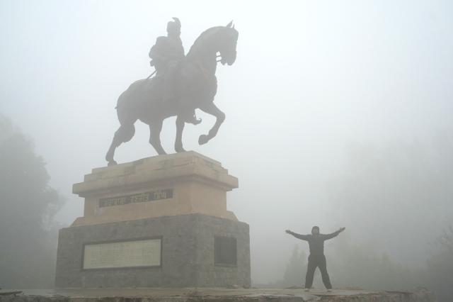 A man exercises beside the statue of Maharaja Ranjit Singh at a garden amid dense smog on a cold winter morning in Amritsar on December 29, 2025. (Photo by Narinder NANU / AFP)