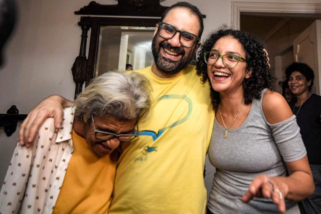 (FILES) British-Egyptian activist Alaa Abdel Fattah (C) embraces his mother, writer Laila Soueif (L), and his sister Sanaa Seif (R), at home after his release in Cairo on September 23, 2025. The British-Egyptian activist apologised on December 29, 2025 for resurfaced social media posts in which he called for violence against Zionists and police, as opposition lawmakers urged the UK government to revoke his citizenship. (Photo by Mohamed EL-RAAI / AFP)
