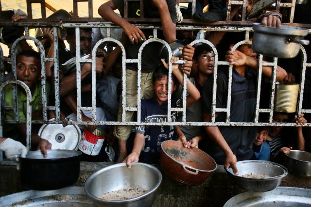 AFP PICTURES OF THE YEAR 2025

Palestinian children wait for a meal at a charity kitchen in the Mawasi area of Khan Yunis in the southern Gaza Strip on July 22, 2025.. The head of Gaza's largest hospital said 21 children have died due to malnutrition and starvation in the Palestinian territory in the past three days, amid a devastating assault by Israeli forces. (Photo by AFP) / AFP PICTURES OF THE YEAR 2025