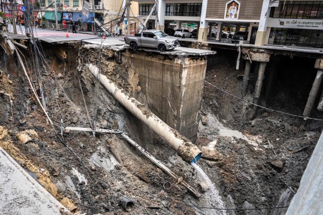 AFP PICTURES OF THE YEAR 2025

A vehicle is seen on the edge of a hole in the ground after a road collapsed near a hospital in Bangkok on September 24, 2025.. A portion of a busy road in Thailand's capital caved in early on September 24, leaving a hole dozens of meters deep in front of a main hospital and forcing people nearby to evacuate. (Photo by Chanakarn Laosarakham / AFP) / AFP PICTURES OF THE YEAR 2025