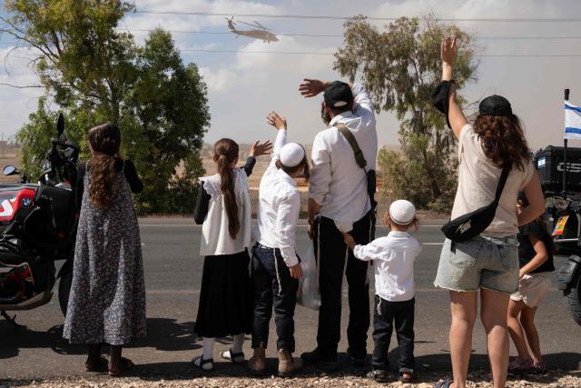 AFP PICTURES OF THE YEAR 2025

Israelis gather with national flags outside the Reim military base near the border with Gaza in southern Israel on October 13, 2025 to welcome the hostages about to arrive following their release by Hamas from the Gaza Strip.. The Palestinian militant group was set to release all surviving Israeli hostages on October 13 in exchange for Palestinian prisoners held by Israel, as US President Donald Trump headed to the region for a peace summit having declared the war "over". Trump's lightning visit to Israel and Egypt aims to celebrate his role in brokering last week's ceasefire and hostage release deal -- but comes at a precarious time as Israel and Hamas negotiate what comes next. (Photo by Maya LEVIN / AFP) / AFP PICTURES OF THE YEAR 2025