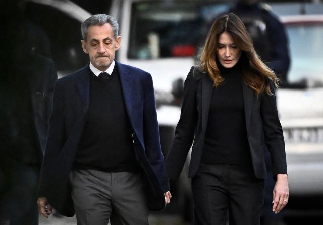 AFP PICTURES OF THE YEAR 2025

France's former president Nicolas Sarkozy (L), with his wife Carla Bruni-Sarkozy, leaves his residence to present himself to La Sante Prison for incarceration on a five-year prison sentence after being convicted of criminal conspiracy over a plan for late Libyan dictator Moamer Kadhafi to fund his 2007 electoral campaign, in Paris, on October 21, 2025.. Nicolas Sarkozy, who has faced a flurry of legal woes since losing re-election in 2012, is to be jailed on October 21, 2025, over a scheme to acquire Libyan funding for his successful 2007 presidential run, becoming the first former head of a European Union country to serve time behind bars. The former French right-wing leader has appealed the verdict and denounced an "injustice". (Photo by JULIEN DE ROSA / AFP) / AFP PICTURES OF THE YEAR 2025