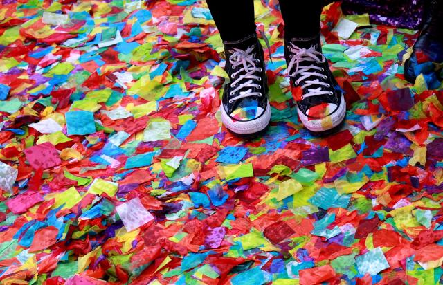 People stand in rain soaked confetti in Times Square during New Year’s Eve rehearsals as part of the Planet Fitness test air worthiness of confetti in New York on December 29, 2025. (Photo by TIMOTHY A. CLARY / AFP)