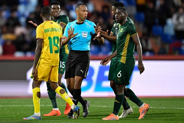Moroccan referee Mustapha Kechchaf (C) comes under pressure to award a penalty during the Africa Cup of Nations (CAN) Group B football match between Zimbabwe and South Africa at Marrakesh Stadium in Marrakesh on December 29, 2025. (Photo by Khaled DESOUKI / AFP)