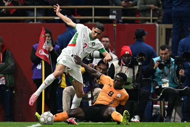 Morocco's defender #02 Achraf Hakimi (L) fights for the ball with Zambia's forward #09 Lameck Banda (C) during the Africa Cup of Nations (CAN) group stage football match between Zambia and Morocco at Prince Moulay Abdellah Stadium in Rabat on December 29, 2025. (Photo by Gabriel BOUYS / AFP)