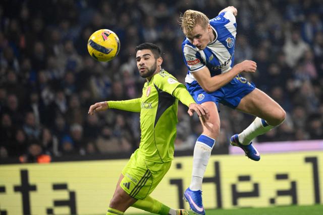 AVS' Paraguayan defender #12 Daniel Rivas (L) and FC Porto's Danish midfielder #08 Victor Froholdt vie for a header during the Portuguese League football match between FC Porto and AVS at Dragao stadium in Porto on December 29, 2025. (Photo by Miguel RIOPA / AFP)