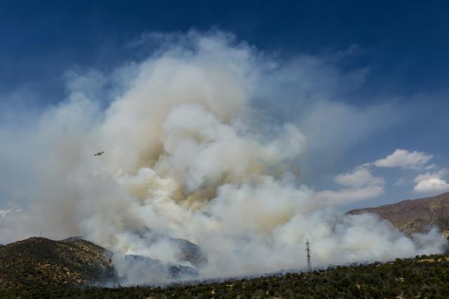 This aerial view shows a forest fire in San Carlos de Apoquindo in Santiago on December 29, 2025. (Photo by Javier TORRES / AFP)