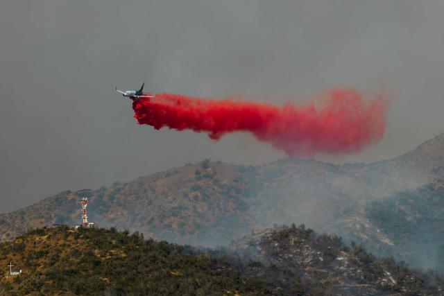 This aerial view shows a plane fighting a forest fire in San Carlos de Apoquindo in Santiago on December 29, 2025. (Photo by Javier TORRES / AFP)