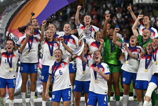 (FILES) England's defender #06 Leah Williamson (CL) and England's midfielder #04 Keira Walsh (CR) lift the trophy as England celebrate winning the UEFA Women's Euro 2025 final football match between England and Spain at the St. Jakob-Park Stadium in Basel, on July 27, 2025. England's "Lionesses" featured heavily in the 2026 New Years Honours List after their Euros win in the summer. Captain Leah Williamson was made a Commander of the Order of the British Empire (CBE), Alex Greenwood, Keira Walsh, Georgia Stanway and Ella Toone, were each made a Member of the Order of the British Empire (MBE) and the team's Dutch manager Sarina Wiegman was awarded an honorary damehood. (Photo by Fabrice COFFRINI / AFP)