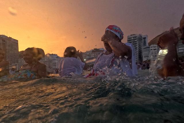 Worshippers pay tribute to Iemanja, the sea goddess of the Afro-Brazilian Umbanda religion, at Copacabana Beach in Rio de Janeiro, Brazil, on December 29, 2025. (Photo by MAURO PIMENTEL / AFP)