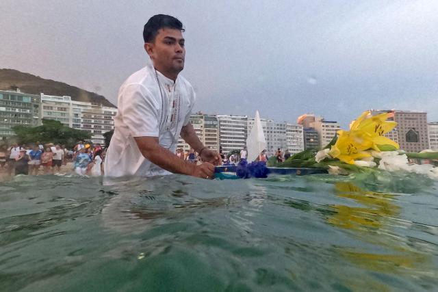 Worshippers pay tribute to Iemanja, the sea goddess of the Afro-Brazilian Umbanda religion, at Copacabana Beach in Rio de Janeiro, Brazil, on December 29, 2025. (Photo by MAURO PIMENTEL / AFP)