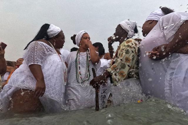 Worshippers pay tribute to Iemanja, the sea goddess of the Afro-Brazilian Umbanda religion, at Copacabana Beach in Rio de Janeiro, Brazil, on December 29, 2025. (Photo by MAURO PIMENTEL / AFP)