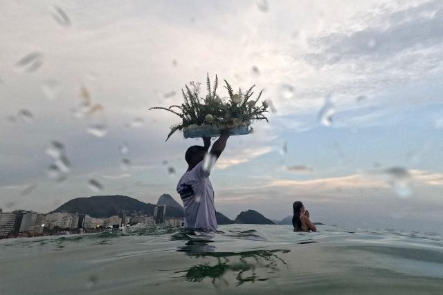 Worshippers pay tribute to Iemanja, the sea goddess of the Afro-Brazilian Umbanda religion, at Copacabana Beach in Rio de Janeiro, Brazil, on December 29, 2025. (Photo by MAURO PIMENTEL / AFP)