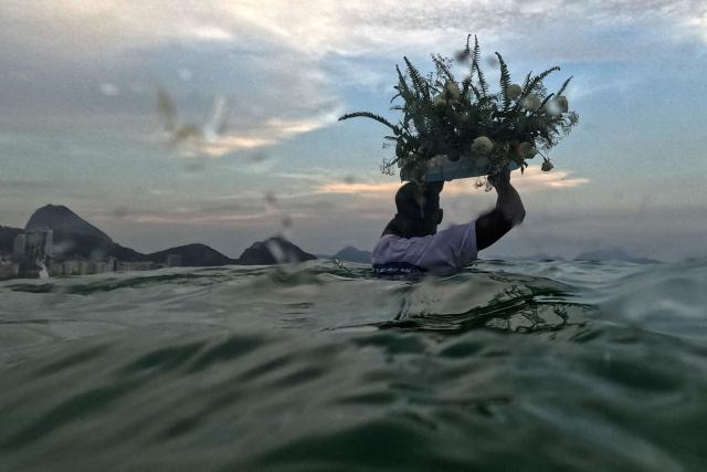 Worshippers pay tribute to Iemanja, the sea goddess of the Afro-Brazilian Umbanda religion, at Copacabana Beach in Rio de Janeiro, Brazil, on December 29, 2025. (Photo by MAURO PIMENTEL / AFP)