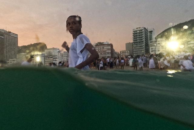 Worshippers pay tribute to Iemanja, the sea goddess of the Afro-Brazilian Umbanda religion, at Copacabana Beach in Rio de Janeiro, Brazil, on December 29, 2025. (Photo by MAURO PIMENTEL / AFP)