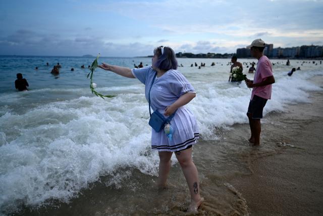 Worshippers pay tribute to Iemanja, the sea goddess of the Afro-Brazilian Umbanda religion, at Copacabana Beach in Rio de Janeiro, Brazil, on December 29, 2025. (Photo by MAURO PIMENTEL / AFP)