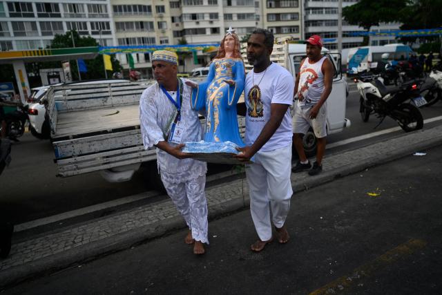Worshippers pay tribute to Iemanja, the sea goddess of the Afro-Brazilian Umbanda religion, at Copacabana Beach in Rio de Janeiro, Brazil, on December 29, 2025. (Photo by MAURO PIMENTEL / AFP)