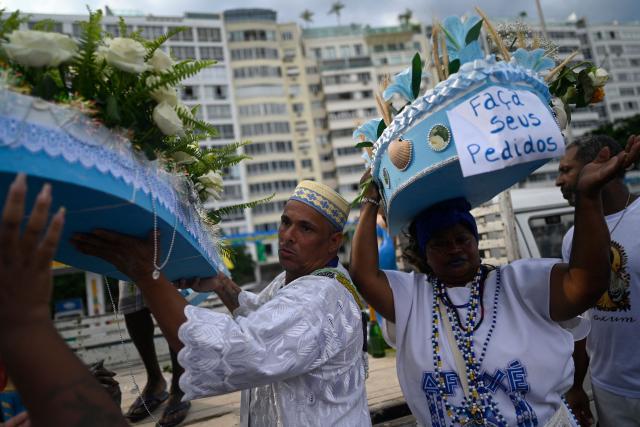 Worshippers pay tribute to Iemanja, the sea goddess of the Afro-Brazilian Umbanda religion, at Copacabana Beach in Rio de Janeiro, Brazil, on December 29, 2025. (Photo by MAURO PIMENTEL / AFP)